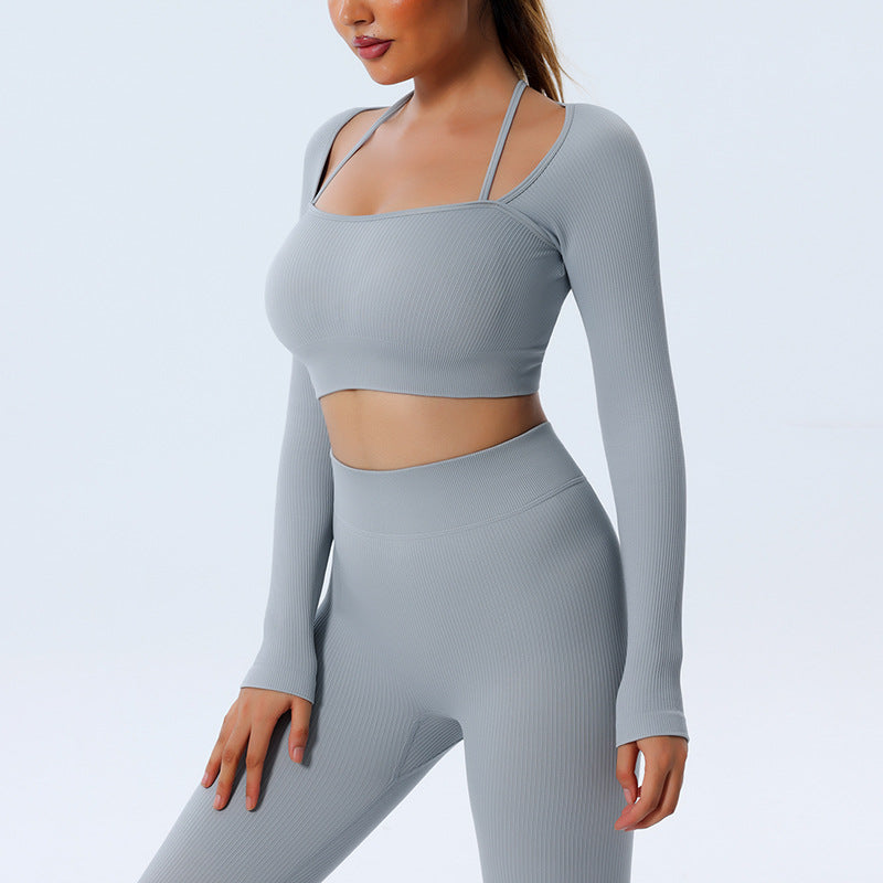 A woman models the cas7m Seamless Yoga Set, featuring a light gray, ribbed long sleeve top and matching high-waisted pants, against a plain background. Her head is partially out of frame.