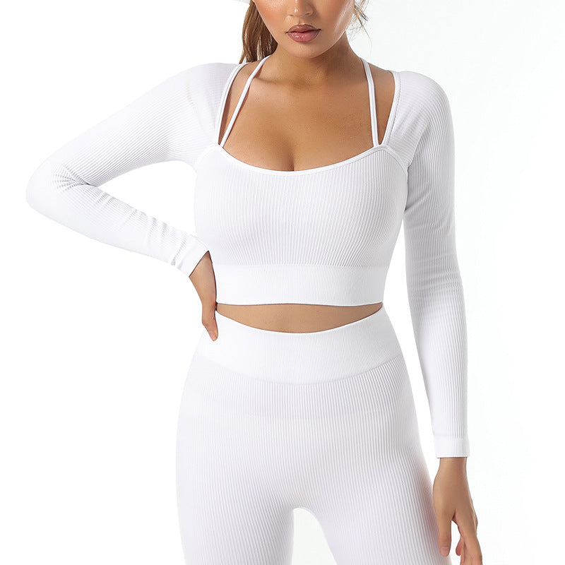 A woman poses with one hand on her hip against a plain white background, wearing the cas7m Seamless Yoga Set with Long Sleeve Top and High-Waisted Pants in white ribbed fabric.